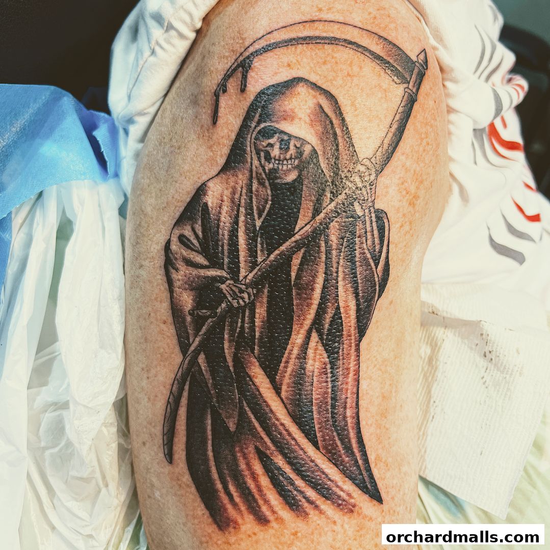 A detailed tattoo of the Grim Reaper with a scythe on a person's arm.