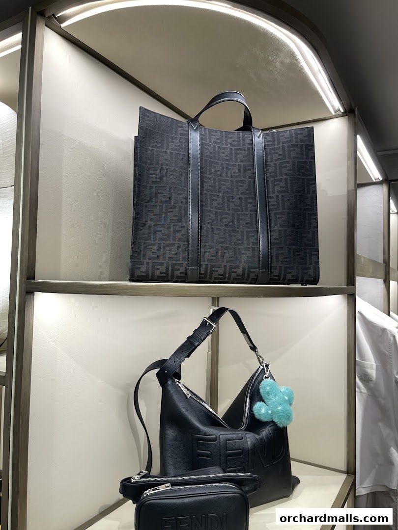 Fendi bags displayed on shelves, including a patterned tote and a black leather hobo bag.