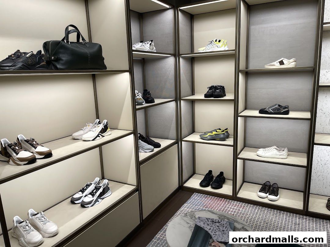 A well-lit display of Fendi sneakers and a handbag on shelves.
