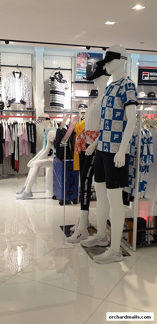 Mannequins display FILA apparel and footwear in a brightly lit retail store.