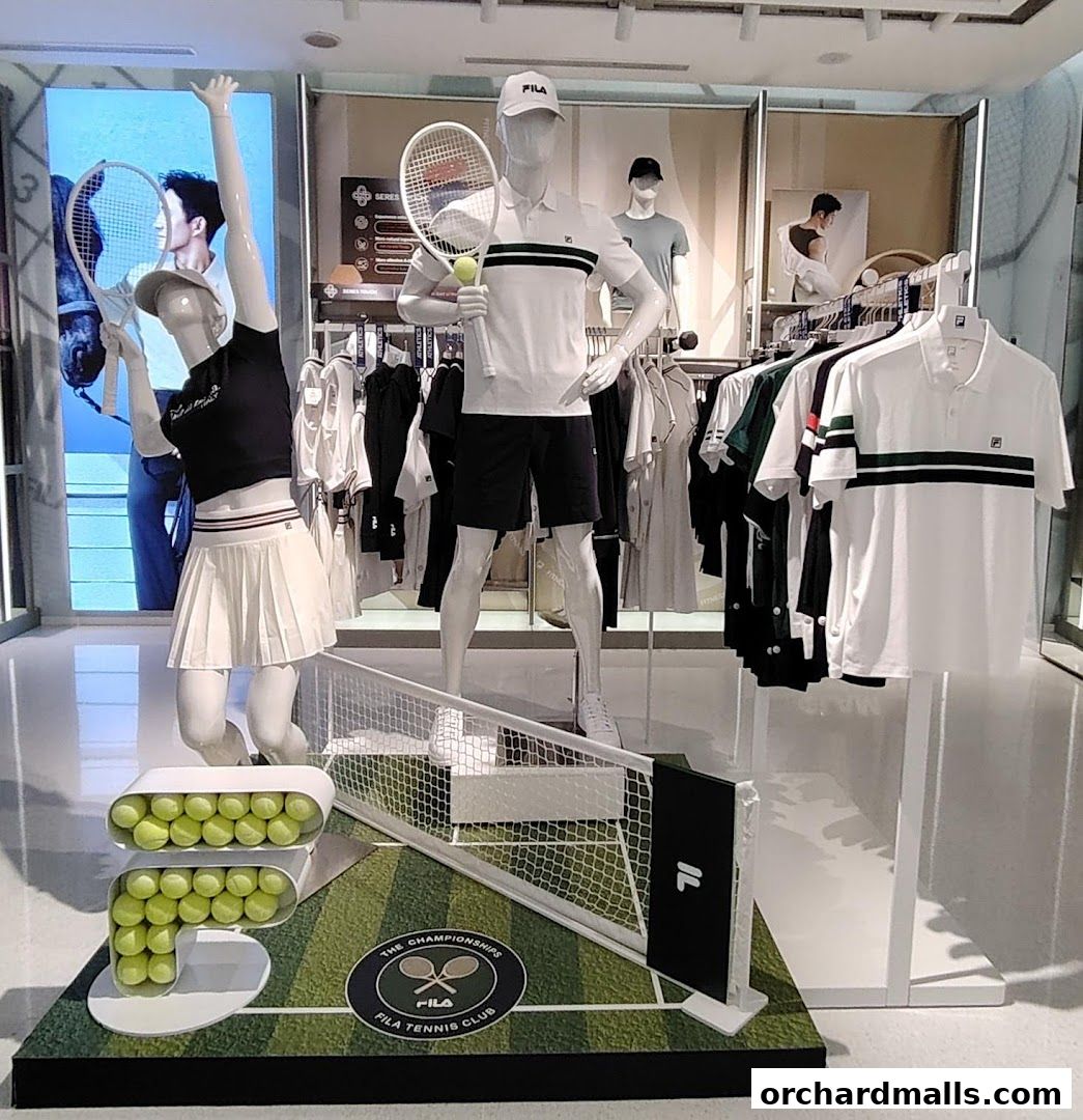 Mannequins dressed in FILA tennis apparel are displayed with tennis rackets and balls.