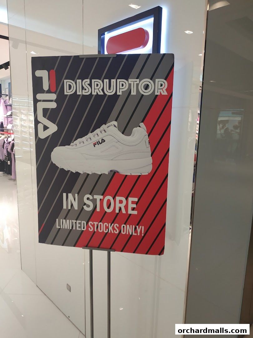 A sign advertising FILA Disruptor shoes, highlighting they are in store with limited stocks.