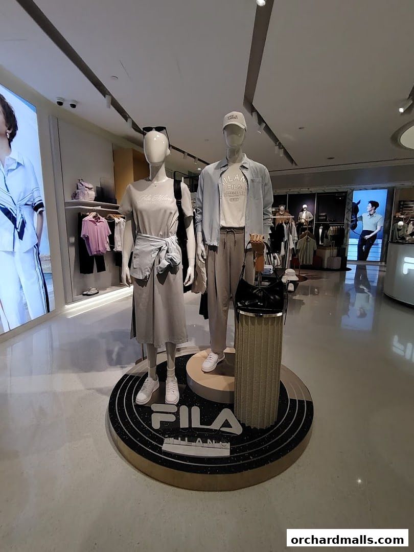 Mannequins display FILA apparel in a modern retail store setting.