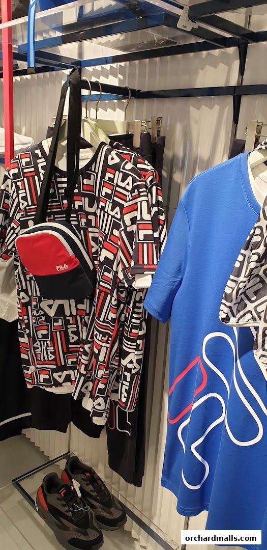 Fila apparel and sneakers displayed on racks and shelves in a retail store.