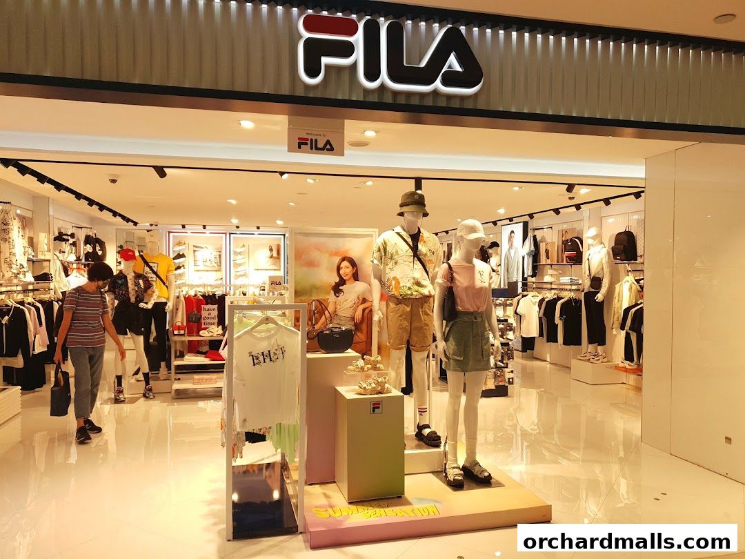 The Fila store front displays mannequins in summer outfits and racks of clothing.