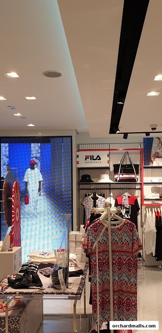 Interior view of a Fila store showcasing apparel, bags, and accessories on display.