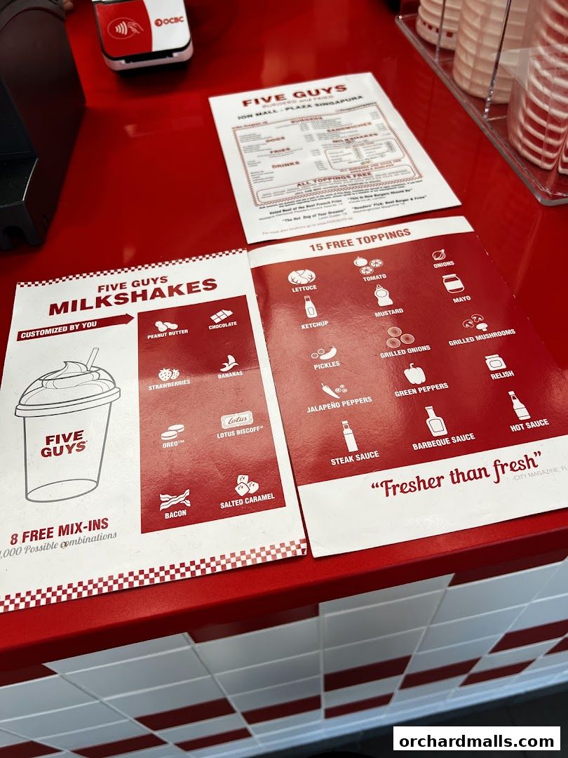 A menu display for Five Guys featuring milkshakes and free toppings for burgers.