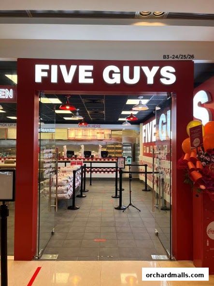 The entrance to the Five Guys restaurant with its iconic red and white branding.