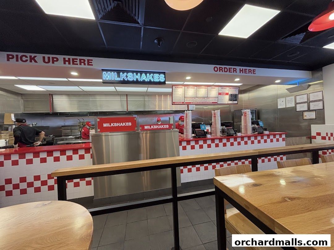 Interior view of a Five Guys restaurant showing the ordering counter and kitchen area.