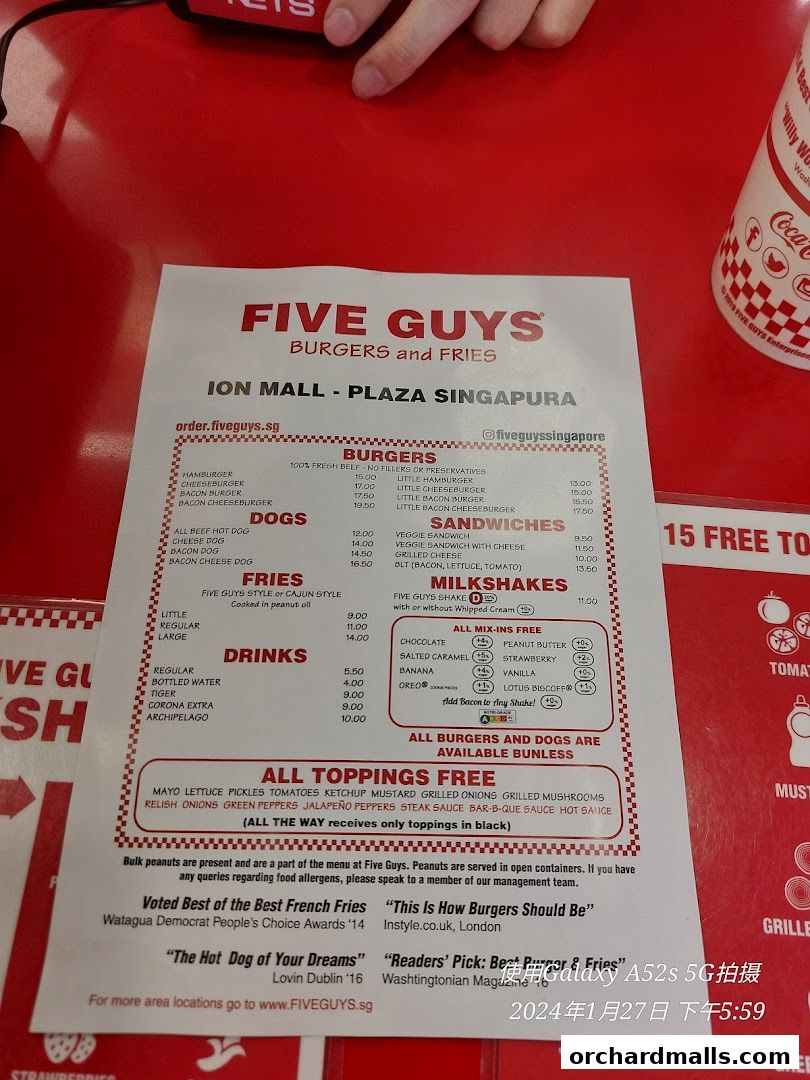 A Five Guys menu displaying burgers, hot dogs, fries, drinks, and milkshakes with prices.