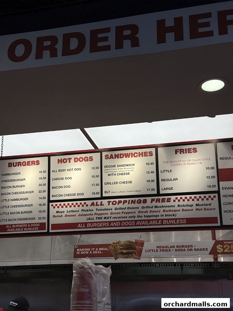 A menu board displaying burgers, hot dogs, sandwiches, and fries with prices.