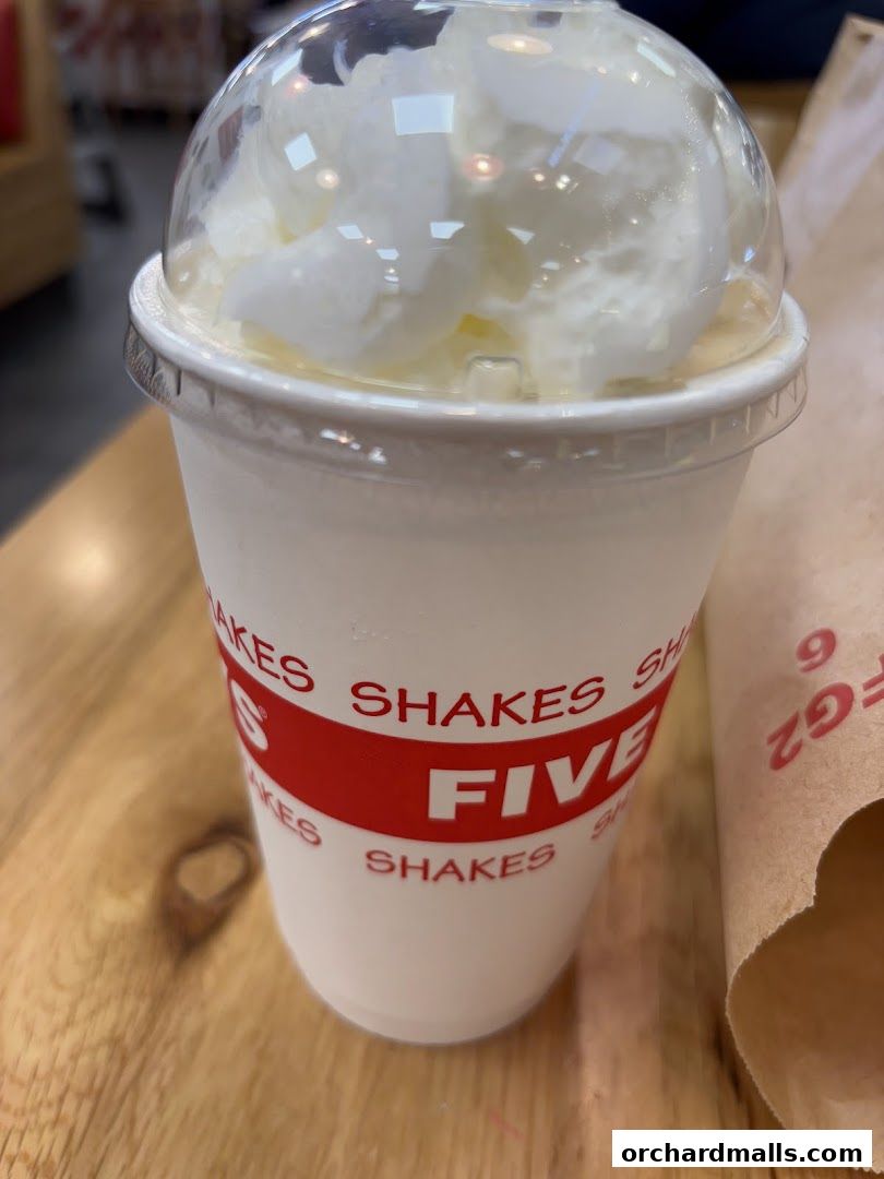 A close-up of a delicious Five Guys milkshake topped with whipped cream.
