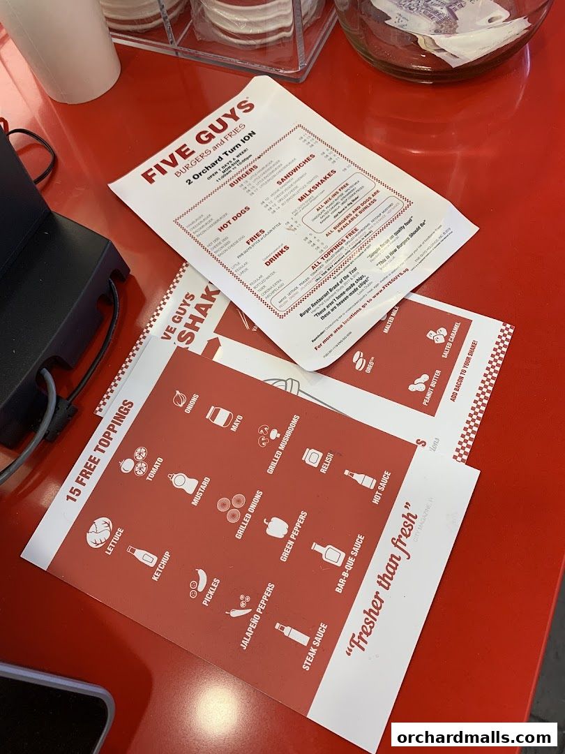 A Five Guys menu displaying burgers, hot dogs, fries, drinks, sandwiches, milkshakes, and free toppings.