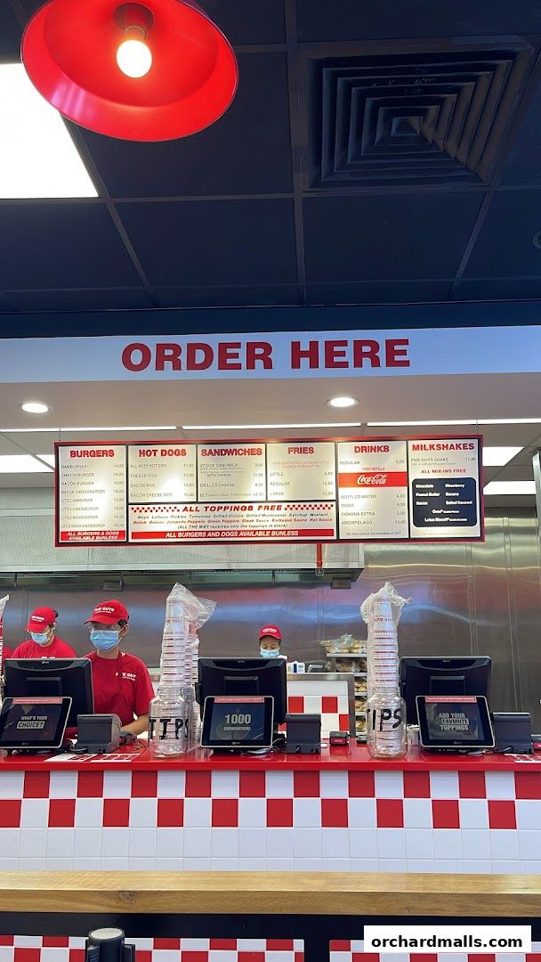 The Five Guys ION Mall counter with staff and a visible menu board above.