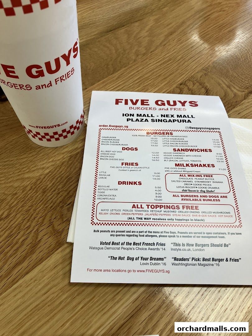 A Five Guys menu with burgers, fries, drinks, and milkshakes, alongside a branded cup.