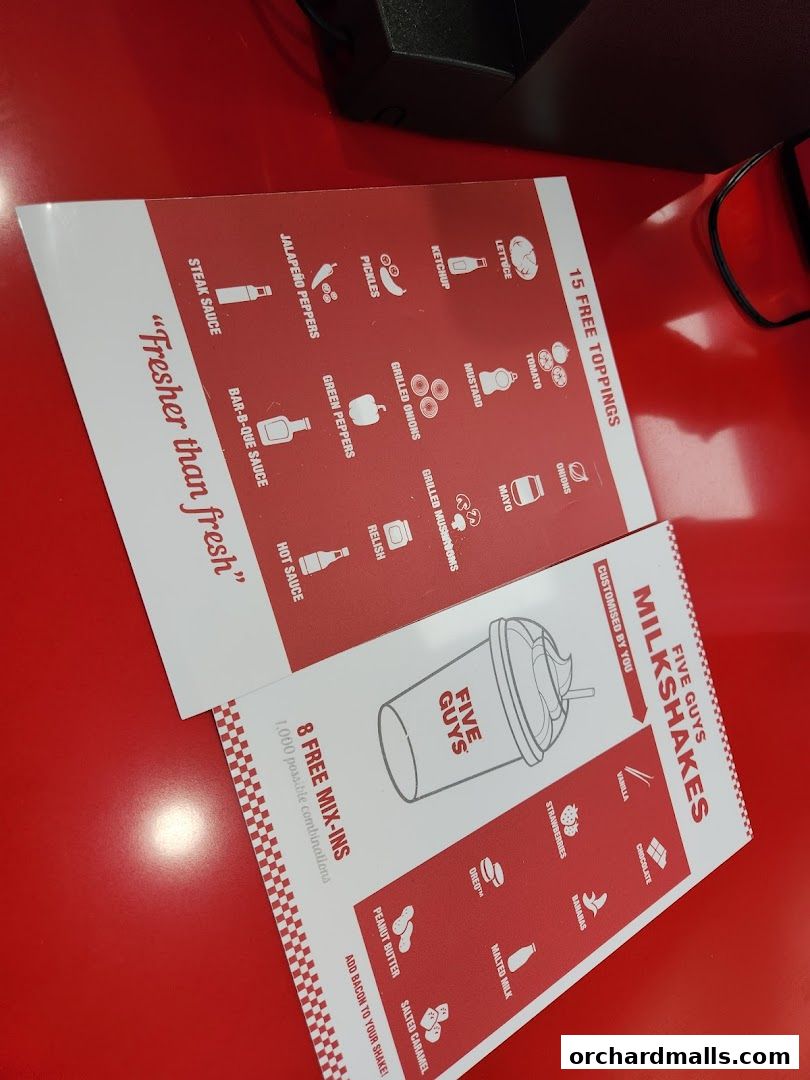 A menu showcasing Five Guys' free toppings and customizable milkshakes.
