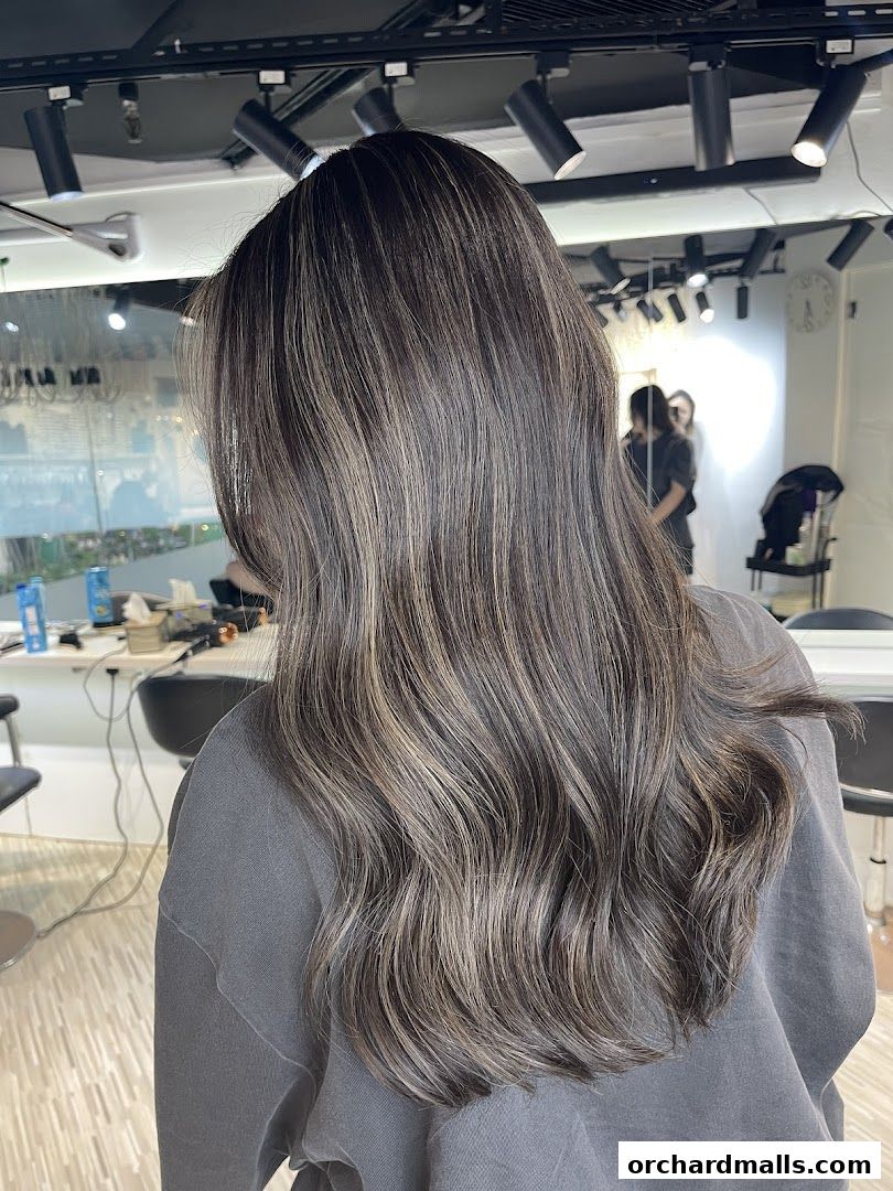 A person with long, wavy, highlighted hair inside a hair studio.