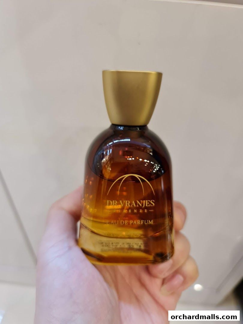 A hand holds a bottle of Dr. Vranjes Firenze Eau de Parfum with a golden cap.