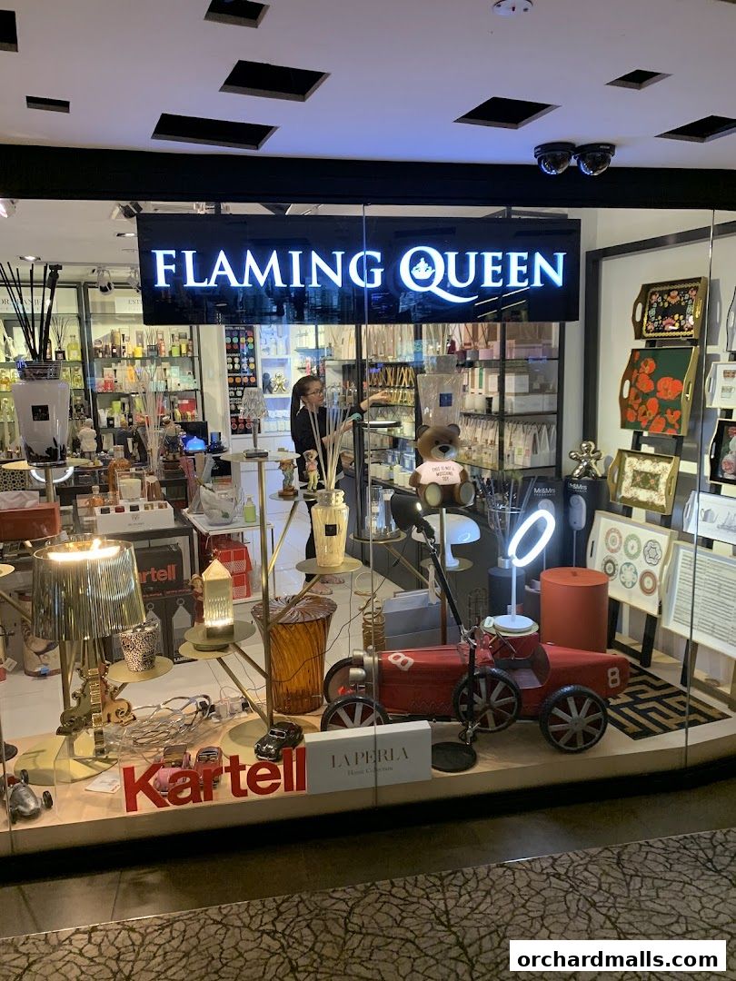 Flaming Queen shop front display featuring decorative items, lamps, and branded products.