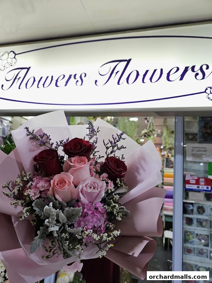 A beautiful bouquet of roses and other flowers in front of a florist shop.