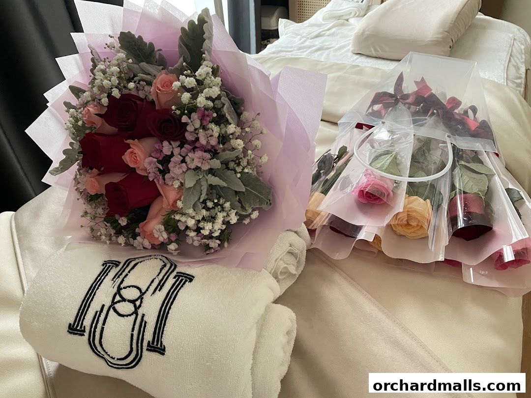 A bouquet of roses and a gift bag of roses with a monogrammed towel.
