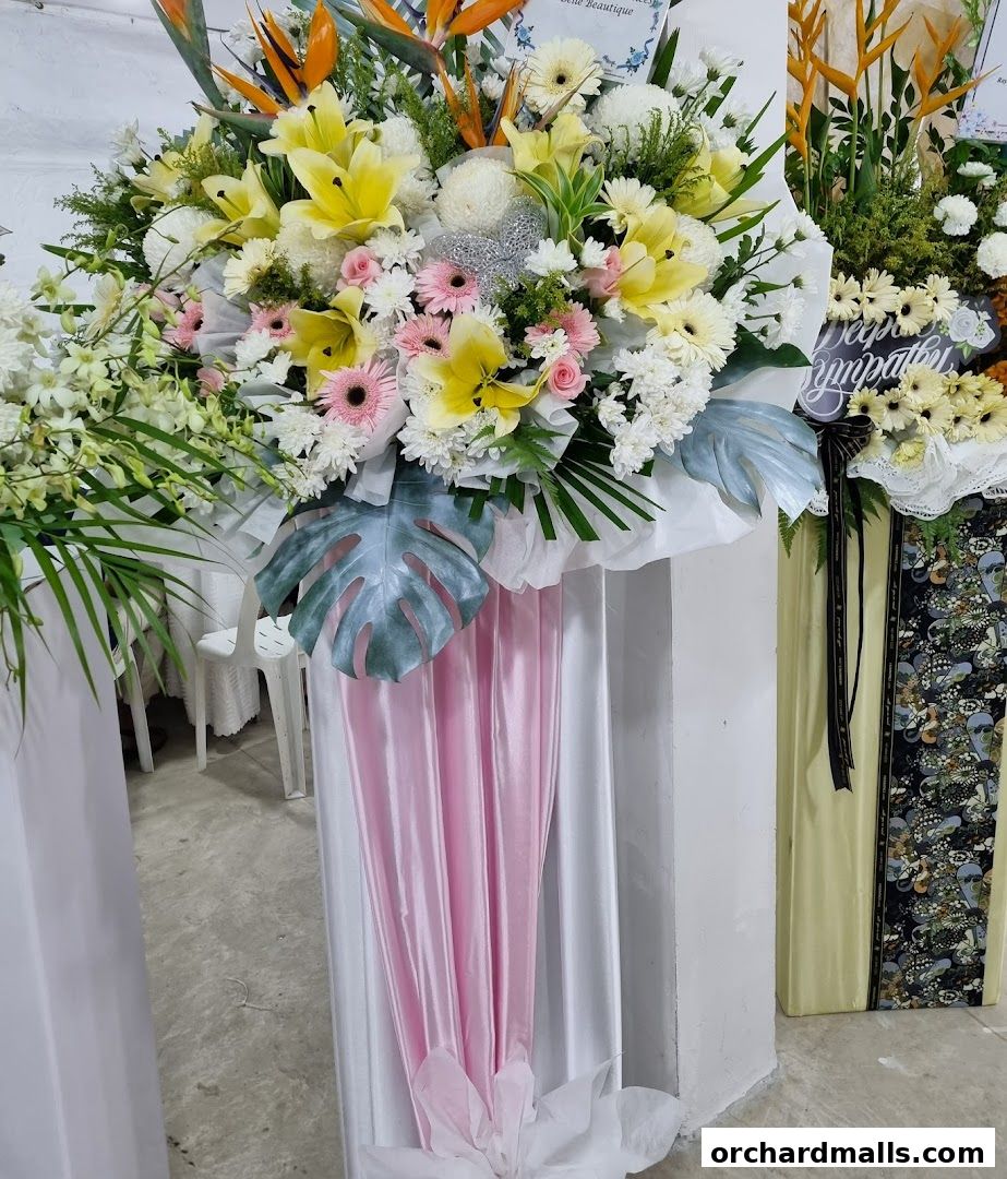 A large, elaborate floral arrangement with lilies, gerberas, and bird of paradise flowers.