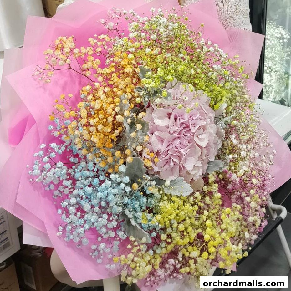 A vibrant bouquet of colorful baby's breath and a pink hydrangea, wrapped in pink paper.
