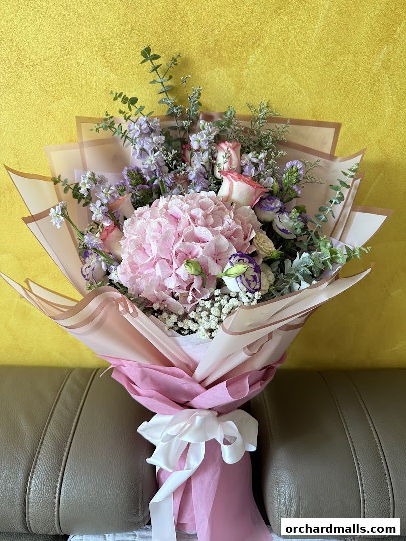 A beautiful bouquet of pink and purple flowers with eucalyptus leaves.