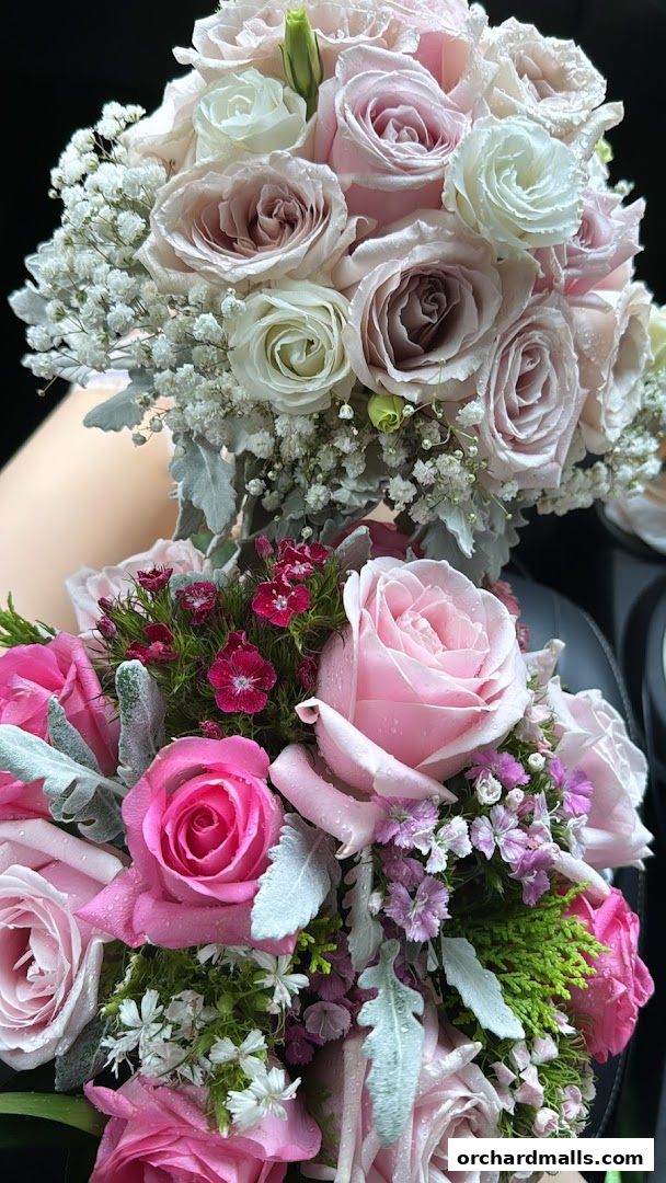 Two beautiful bouquets of roses and baby's breath with water droplets.