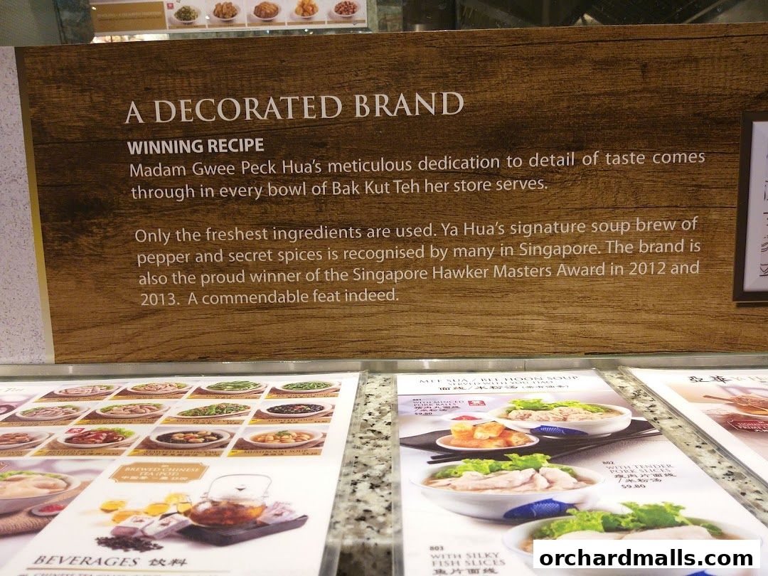 A sign detailing the history and awards of a food brand, with menus below.