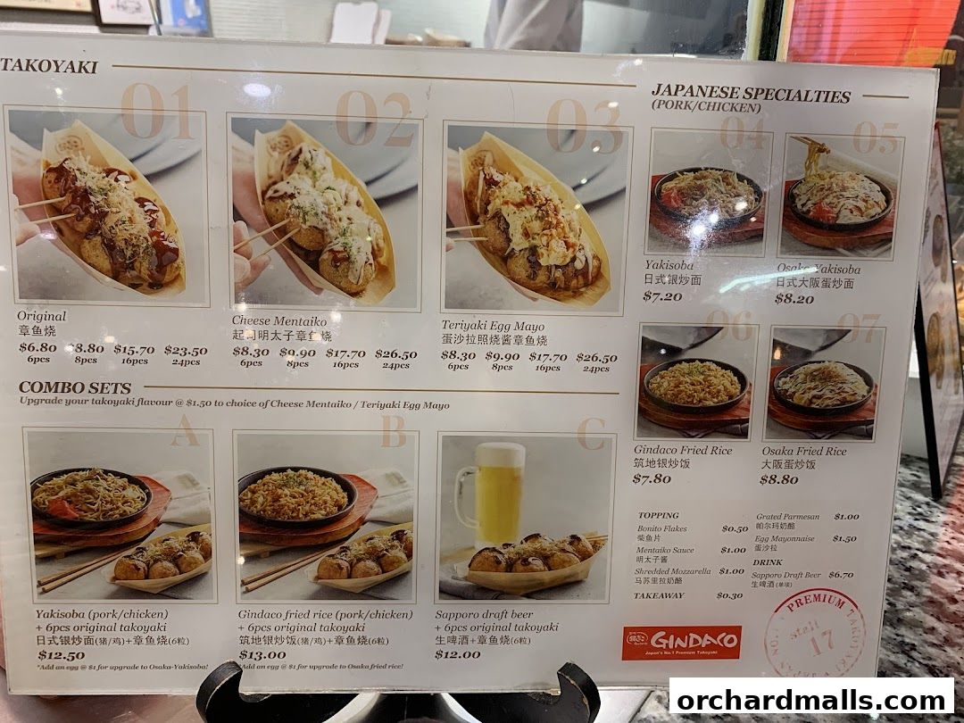 A menu board displaying various Japanese takoyaki, yakisoba, and fried rice dishes with prices.