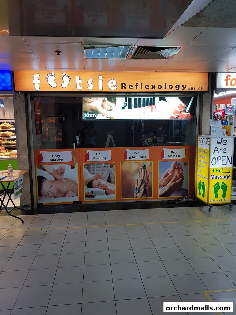 The exterior of Footsie Reflexology shop, showcasing services like body massage, ear candling, and foot massage.