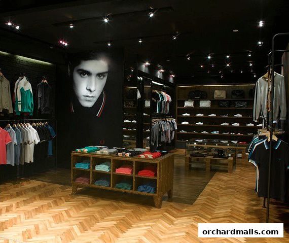 Interior view of a Fred Perry clothing store showcasing apparel and accessories.