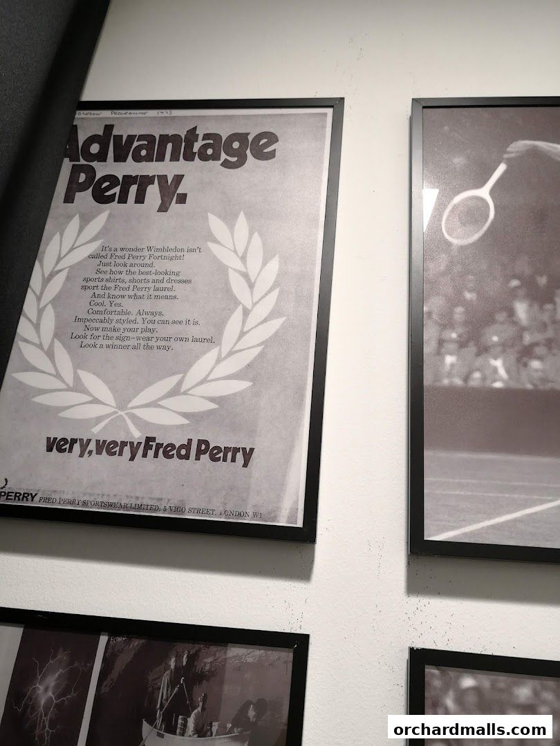 A framed vintage advertisement for Fred Perry sportswear featuring tennis imagery and text.