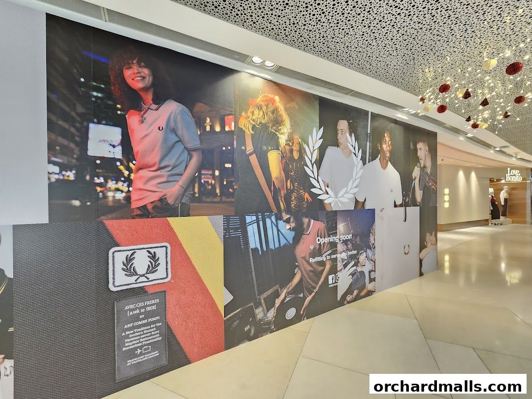 A large graphic display for Fred Perry featuring models and branding, with a glimpse of the Love Bonito store.