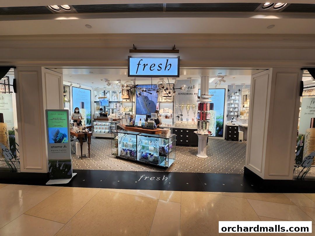 The entrance of a brightly lit Fresh beauty store showcasing various skincare and beauty products.