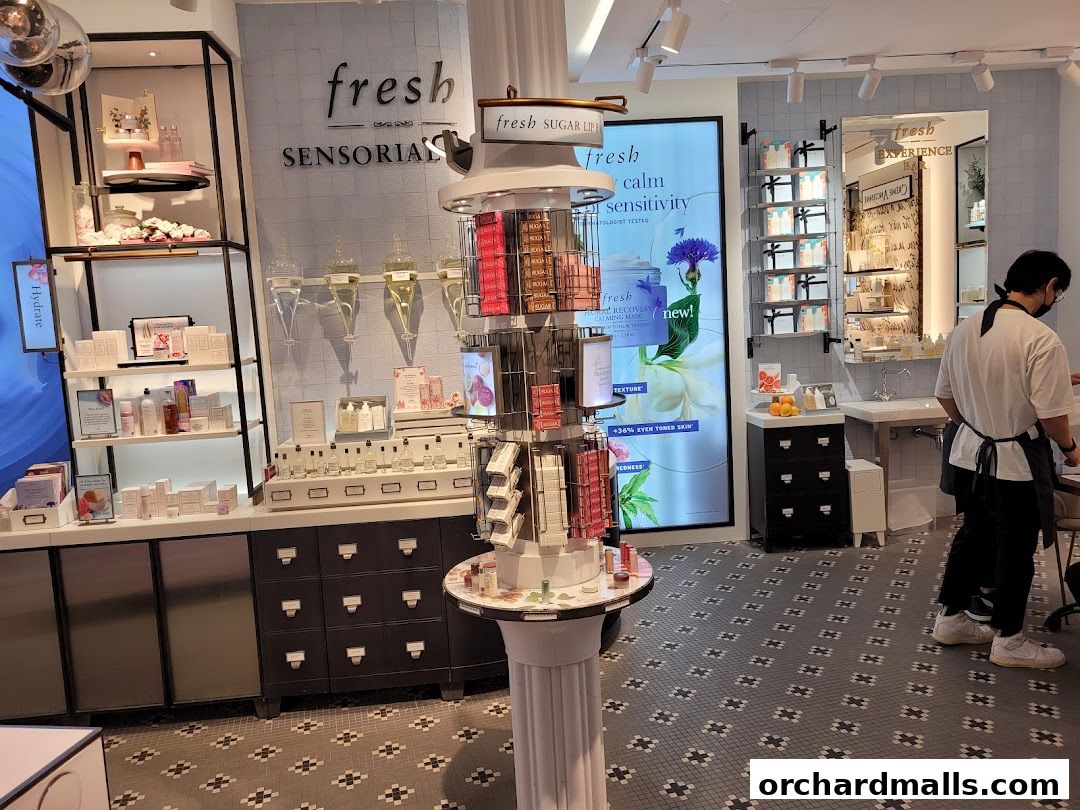 Interior of a Fresh cosmetics store with skincare products displayed on shelves and a rotating display.