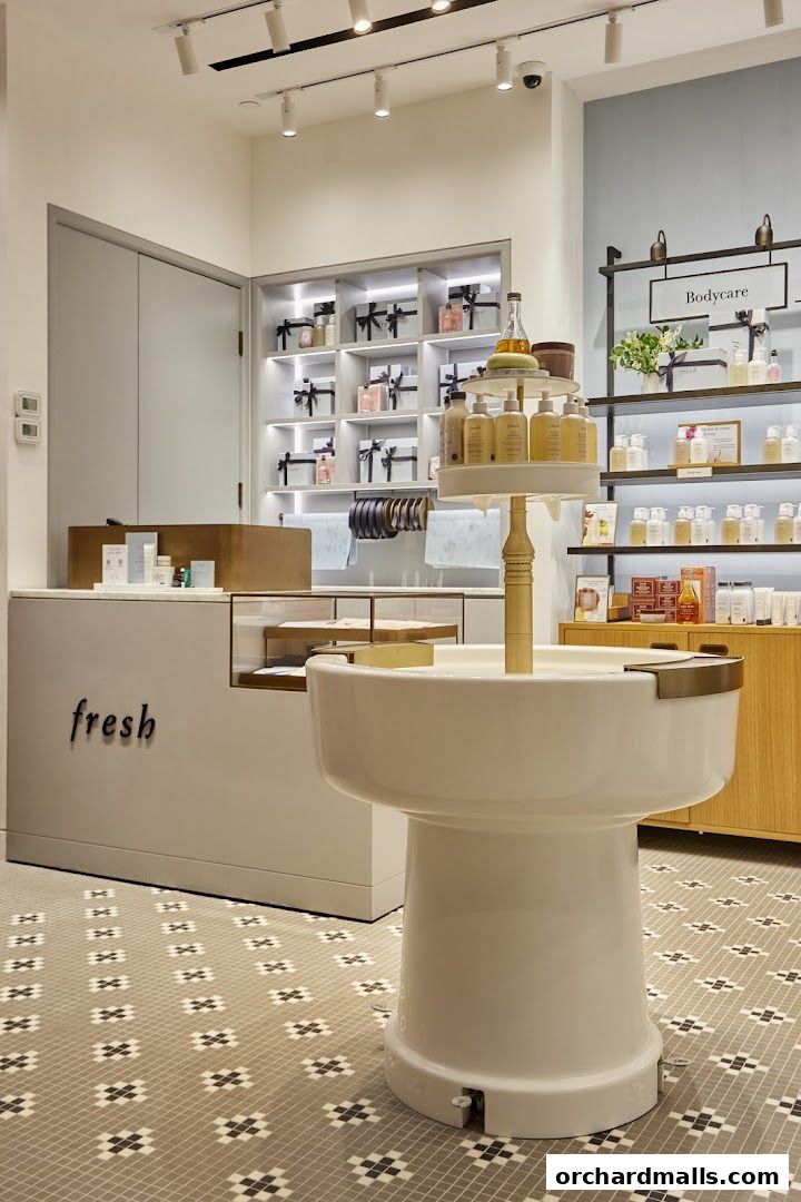 Interior view of a Fresh cosmetics store with product displays and a central display stand.