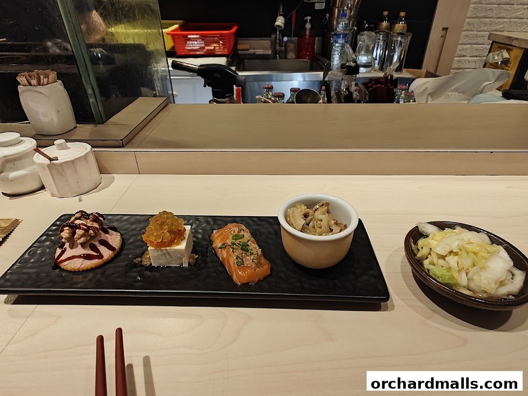 A selection of small Japanese dishes served at a counter.