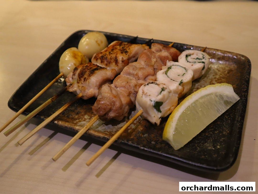 A plate of grilled yakitori skewers with quail eggs and lemon slice.