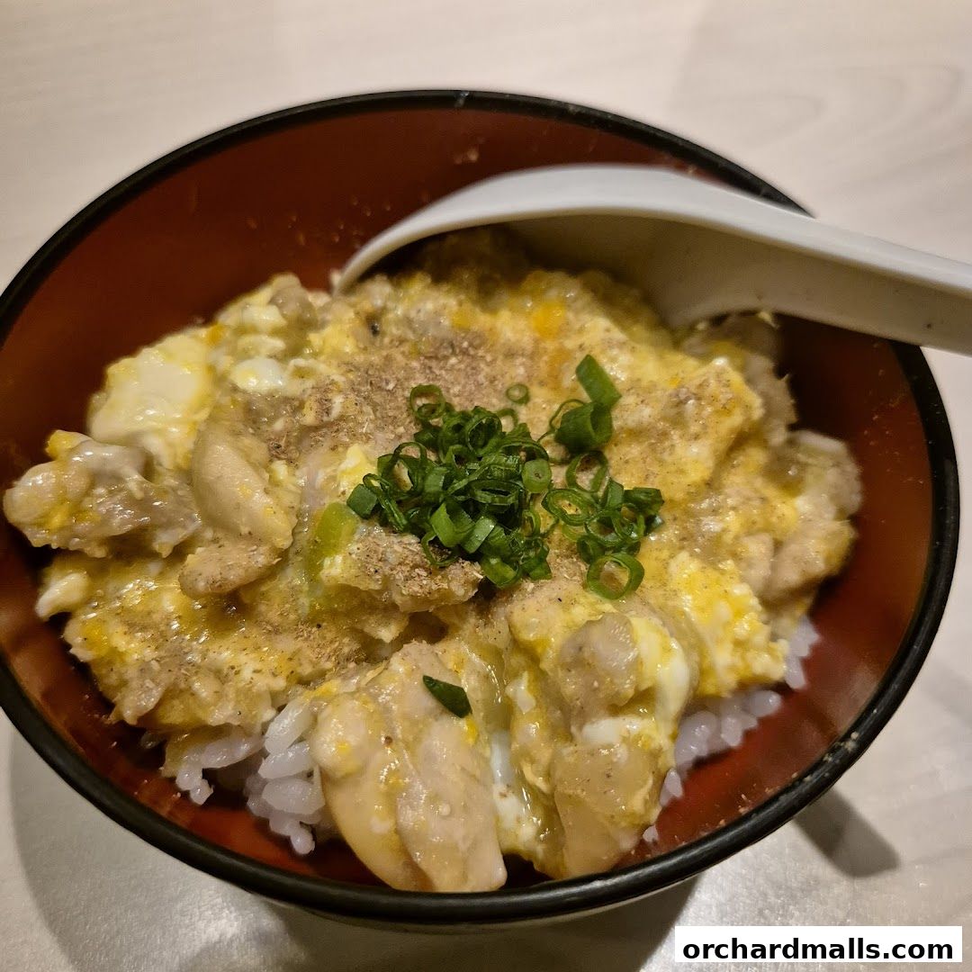 A close-up of a delicious Oyakodon dish served in a traditional Japanese bowl.