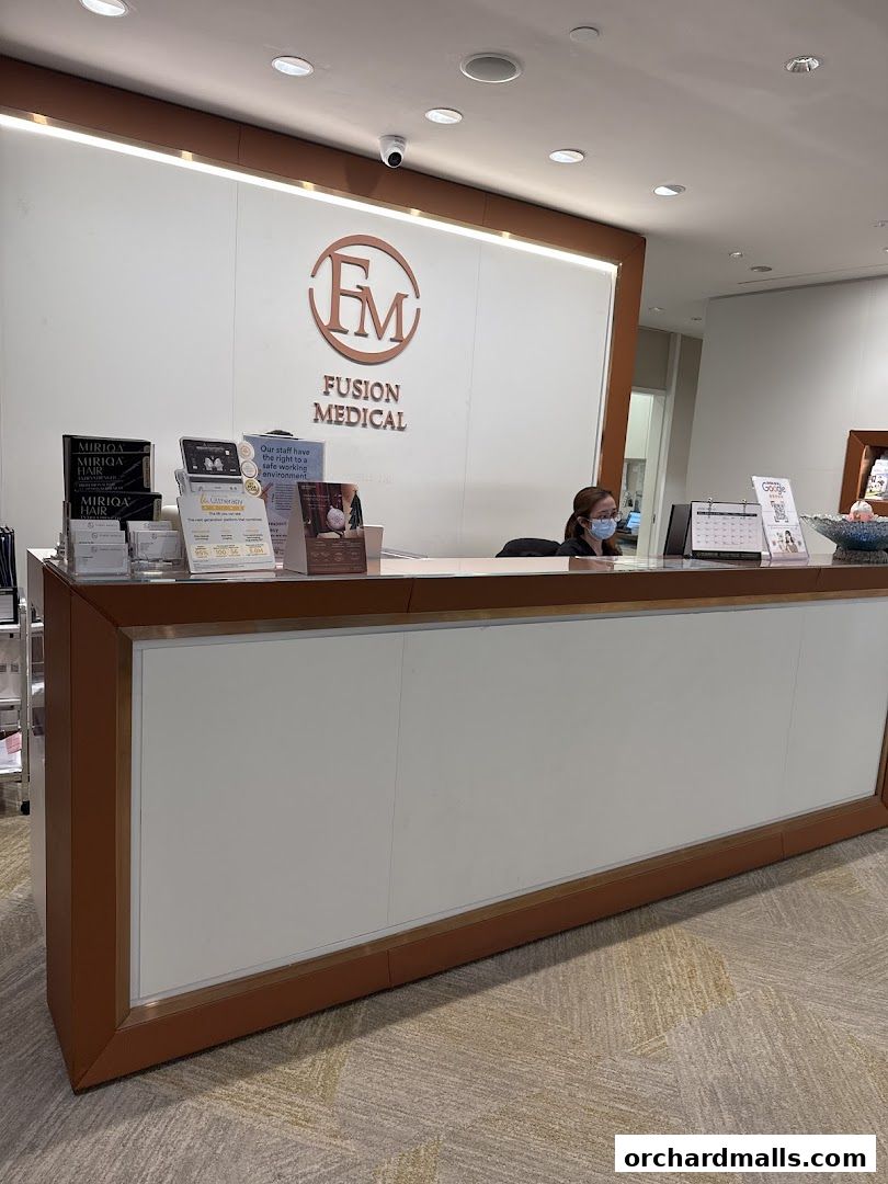 Reception desk at Fusion Medical with staff member and promotional materials.