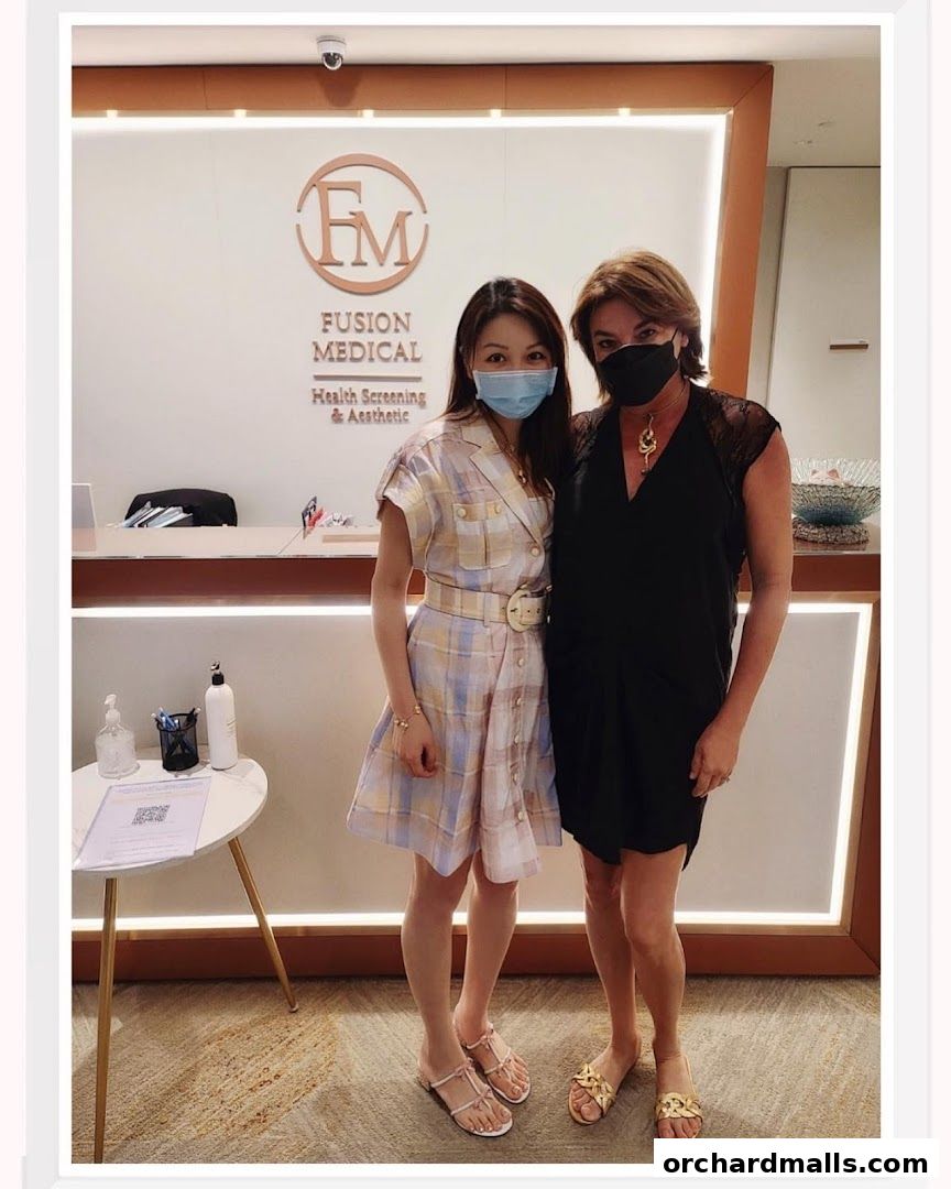 Two women stand in front of the Fusion Medical reception desk.