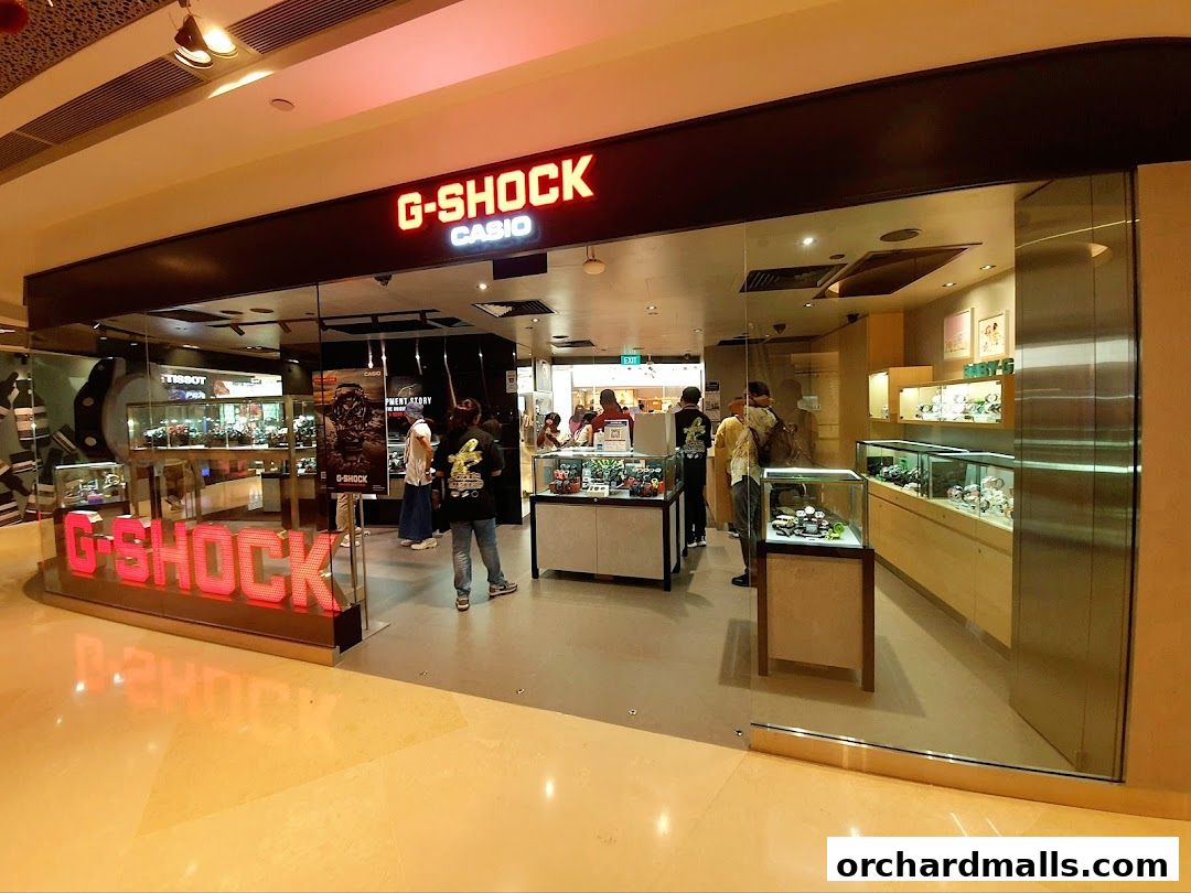 Interior view of a G-SHOCK CASIO watch store with displays and customers.