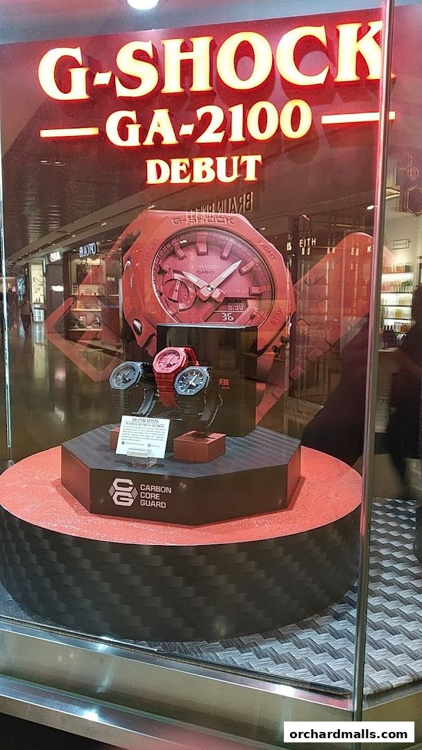 G-SHOCK GA-2100 watches displayed in a shop window with a large red watch model.