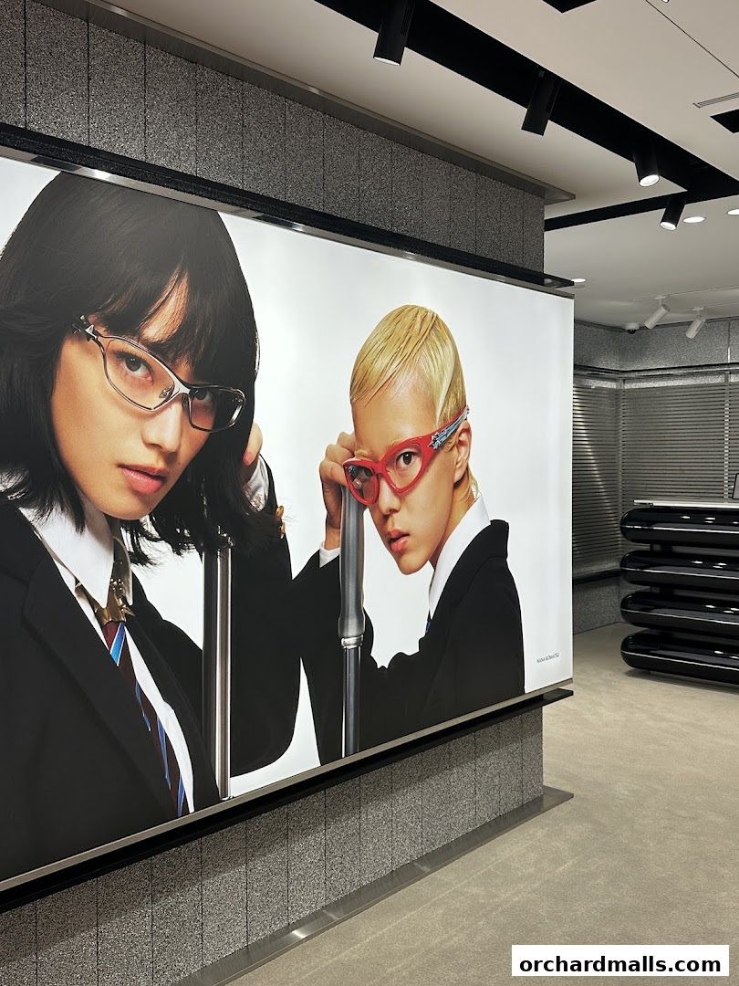 Large advertisement featuring two models wearing stylish eyewear inside a modern retail store.