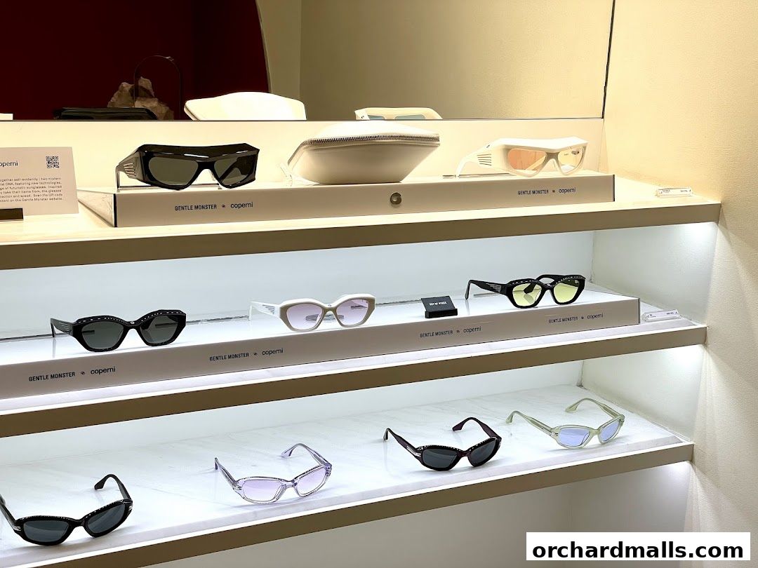 A display of various stylish sunglasses from Gentle Monster and Coperni on illuminated shelves.