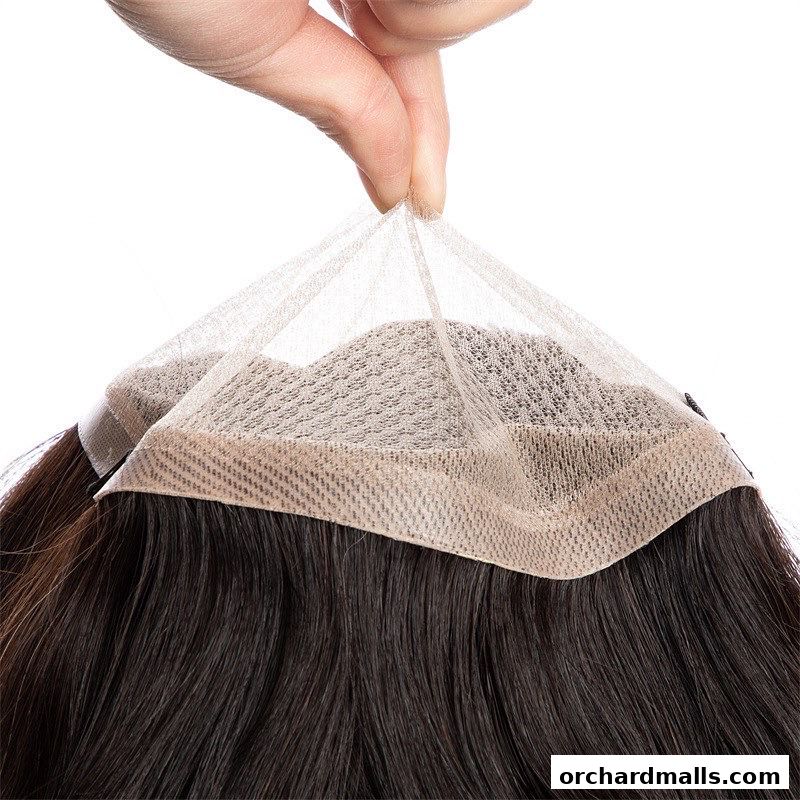 A hand holds the delicate lace base of a dark brown wig.