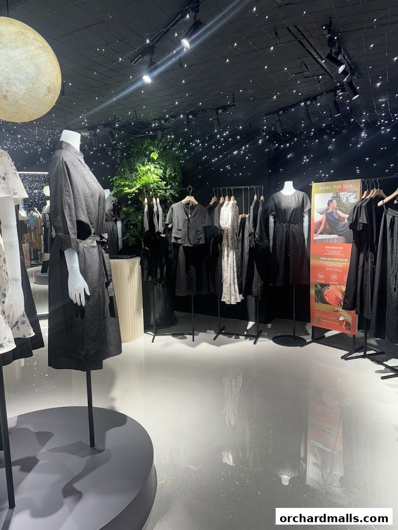 Interior of a clothing store with mannequins and racks of black and white apparel.