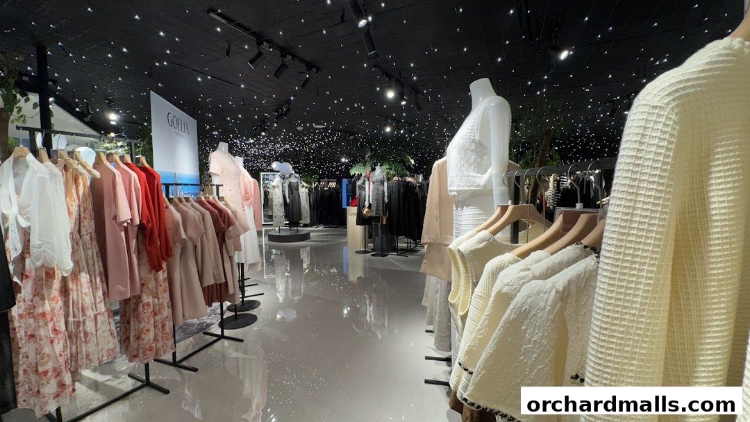 Interior view of a clothing store with racks of dresses and sweaters, and mannequins.